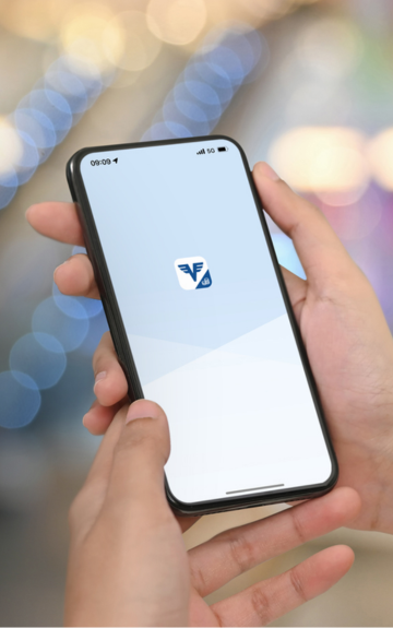 Die hausbanking App der Volksbanken startet auf einem Handyscreen in den Händen einer Person.